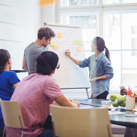 Team members discussing and collaborating at a meeting.